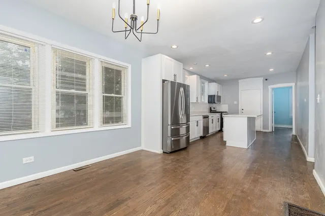 a view of a kitchen with refrigerator and windows