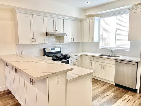 a kitchen with white cabinets and white appliances