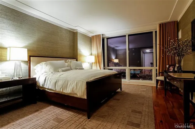 a spacious bedroom with a bed and a lamp