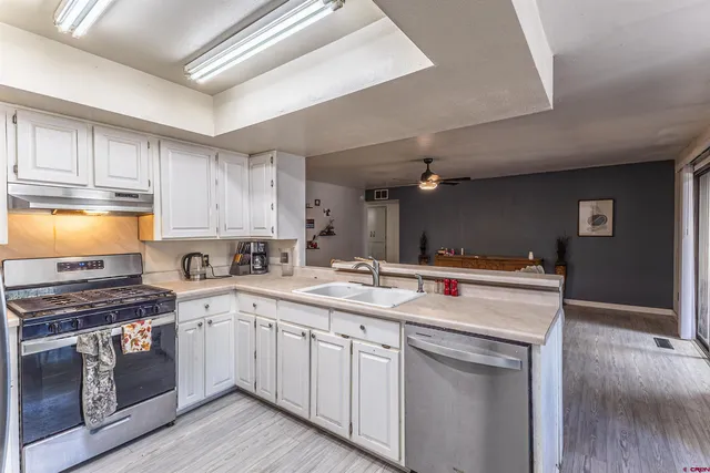 a kitchen with a sink stove top oven and cabinets