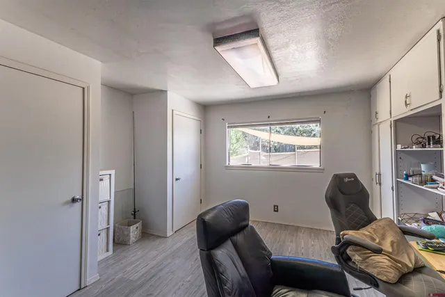 a view of a workspace with furniture and a window