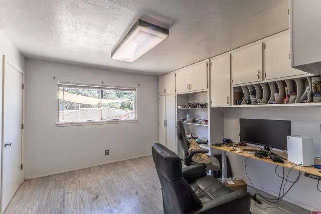 a view of a workspace with furniture and a window