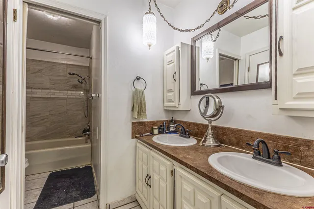 a bathroom with a granite countertop sink a mirror and a shower
