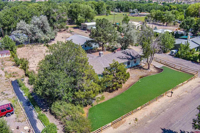 an aerial view of a house with a yard and lake view