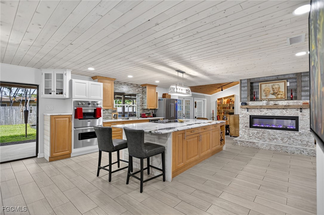 1549 Braeburn Road Fort Myers, FL 33919 - Photo 12 of 38 a kitchen with stainless steel appliances kitchen island granite countertop a table chairs and a refrigerator
