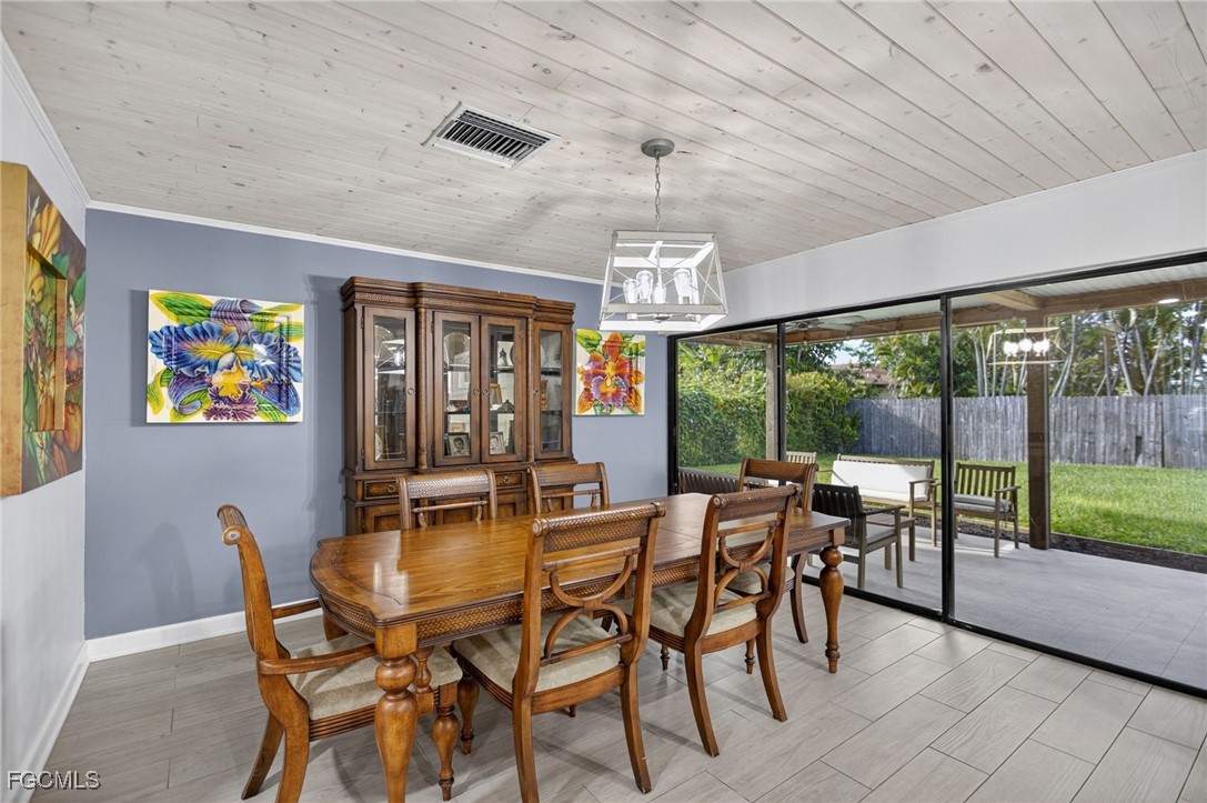 1549 Braeburn Road Fort Myers, FL 33919 - Photo 14 of 38 a view of a dining room with furniture large windows and a chandelier