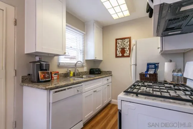 a kitchen with stainless steel appliances granite countertop a sink stove and cabinets