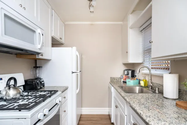 a kitchen with stainless steel appliances granite countertop a sink stove and refrigerator