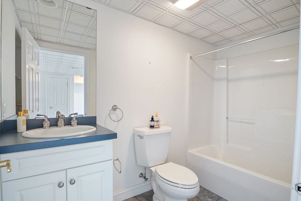 163 Little Harbor Road, Unit 163 New Castle, NH 03854 - Photo 15 of 36 a bathroom with a toilet a sink a mirror a bathtub and vanity