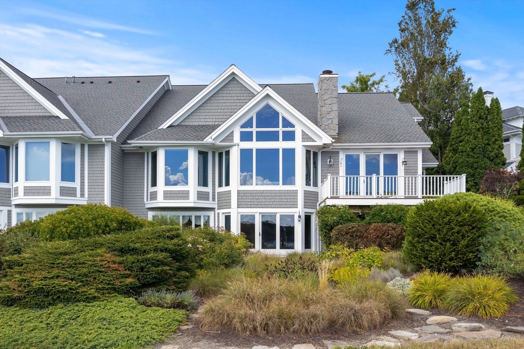 163 Little Harbor Road, Unit 163 New Castle, NH 03854 - Photo 2 of 36 a front view of a house with a yard and potted plants