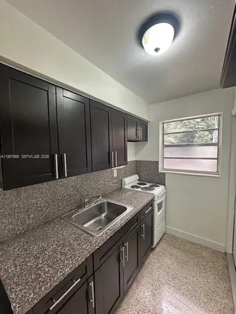 a kitchen with granite countertop a stove and a sink