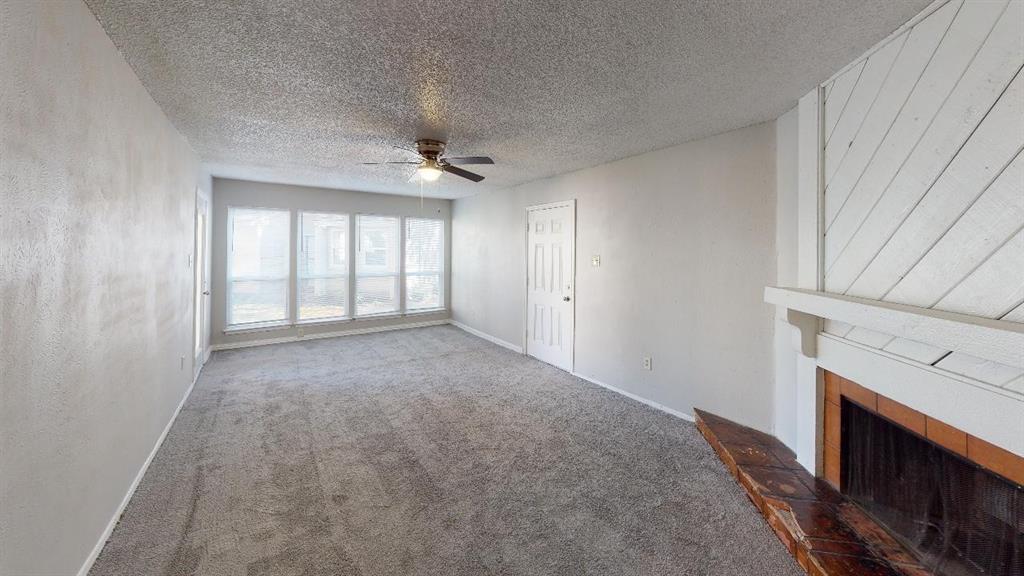 9696 Walnut Street, Unit 1203 Dallas, TX 75243 - Photo 2 of 6 a view of an empty room with a fireplace and a window
