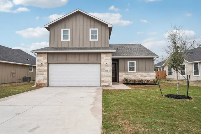a front view of a house with a yard and garage