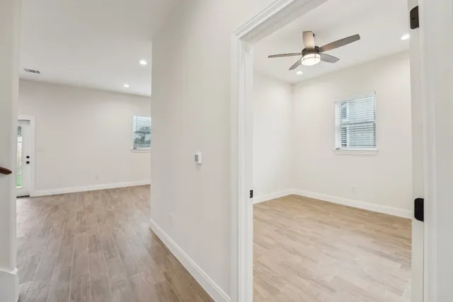 a view of an empty room with wooden floor