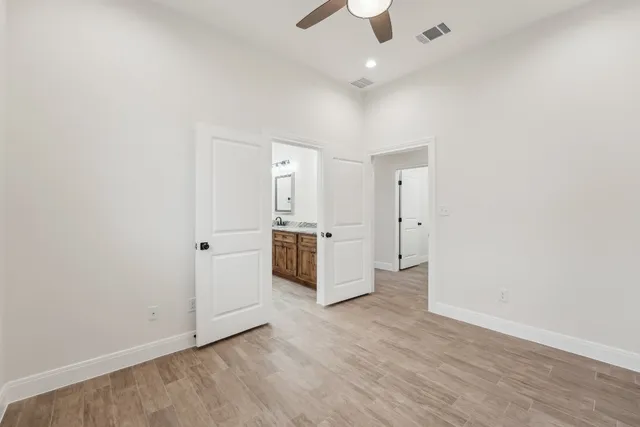 an empty room with a kitchen and a ceiling fan