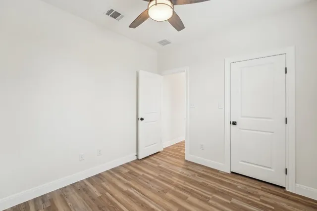 a view of an empty room with wooden floor