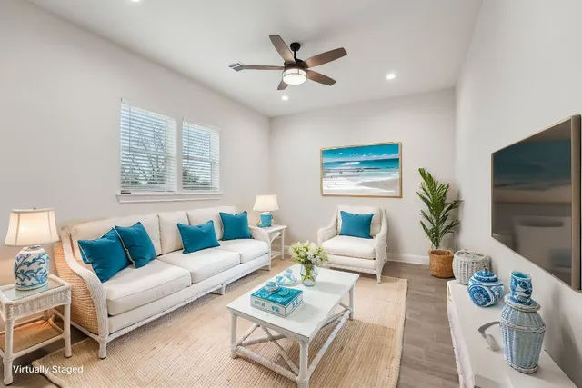 a living room with furniture a flat screen tv and a potted plant