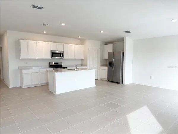 a large kitchen with cabinets and stainless steel appliances