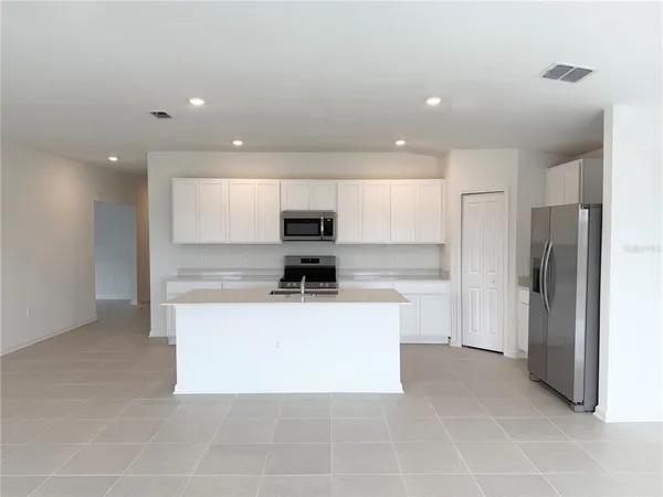 a view of kitchen with stainless steel appliances a refrigerator and a stove