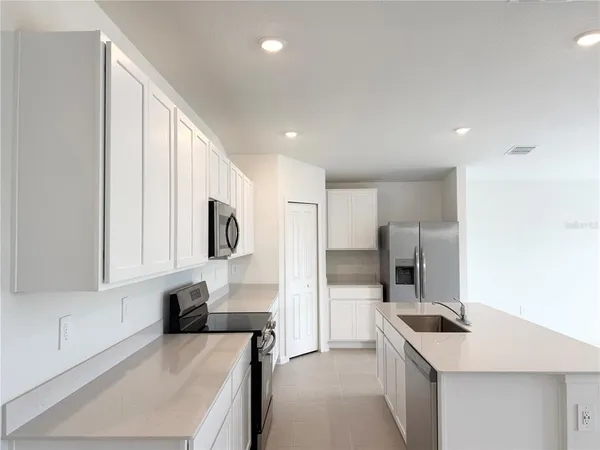 a kitchen with a sink a stove and refrigerator