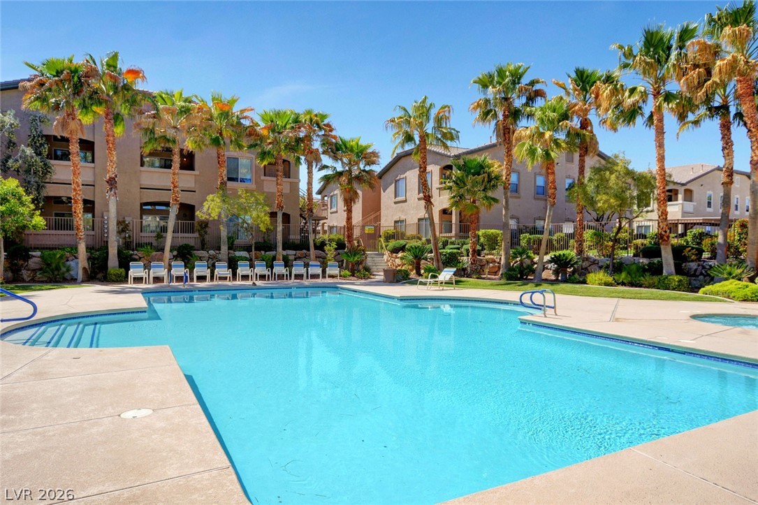 8985 South Durango Drive, Unit 2187 Las Vegas, NV 89113 - Photo 6 of 73 An inviting pool oasis awaits, surrounded by mature palm trees and comfortable lounge seating.
