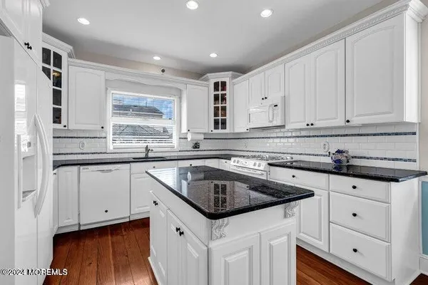 a kitchen with granite countertop a sink and cabinets