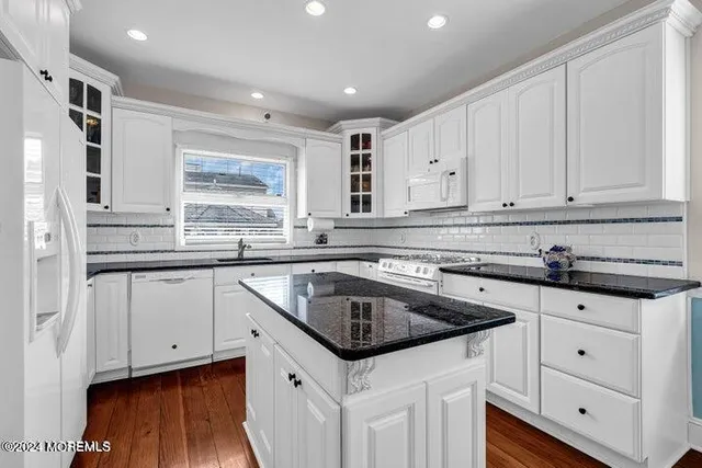 a kitchen with granite countertop a sink and cabinets