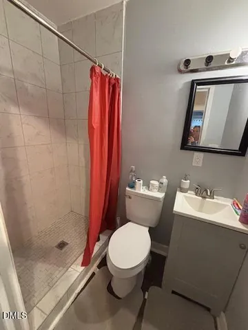 a bathroom with a toilet sink and shower curtain