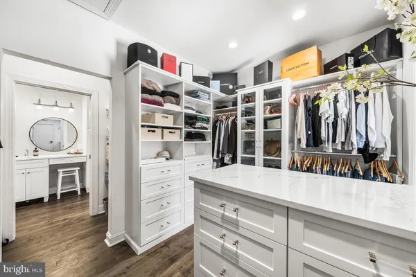 a view of walk in closet with clothes and shoes