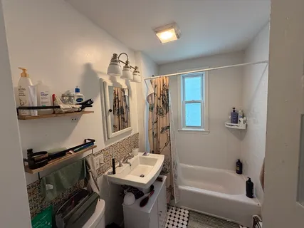 a bathroom with a tub sink and mirror