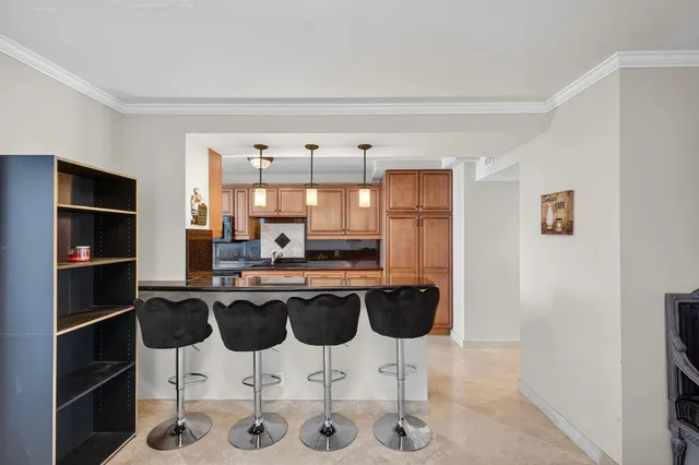 a kitchen with stainless steel appliances granite countertop a refrigerator a sink dishwasher a stove and white cabinets with wooden floor