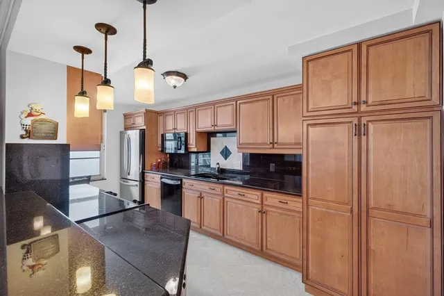 a kitchen with granite countertop a sink a stove and wooden cabinets