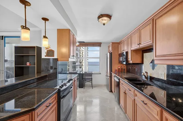 a kitchen with stainless steel appliances granite countertop a stove sink and cabinets