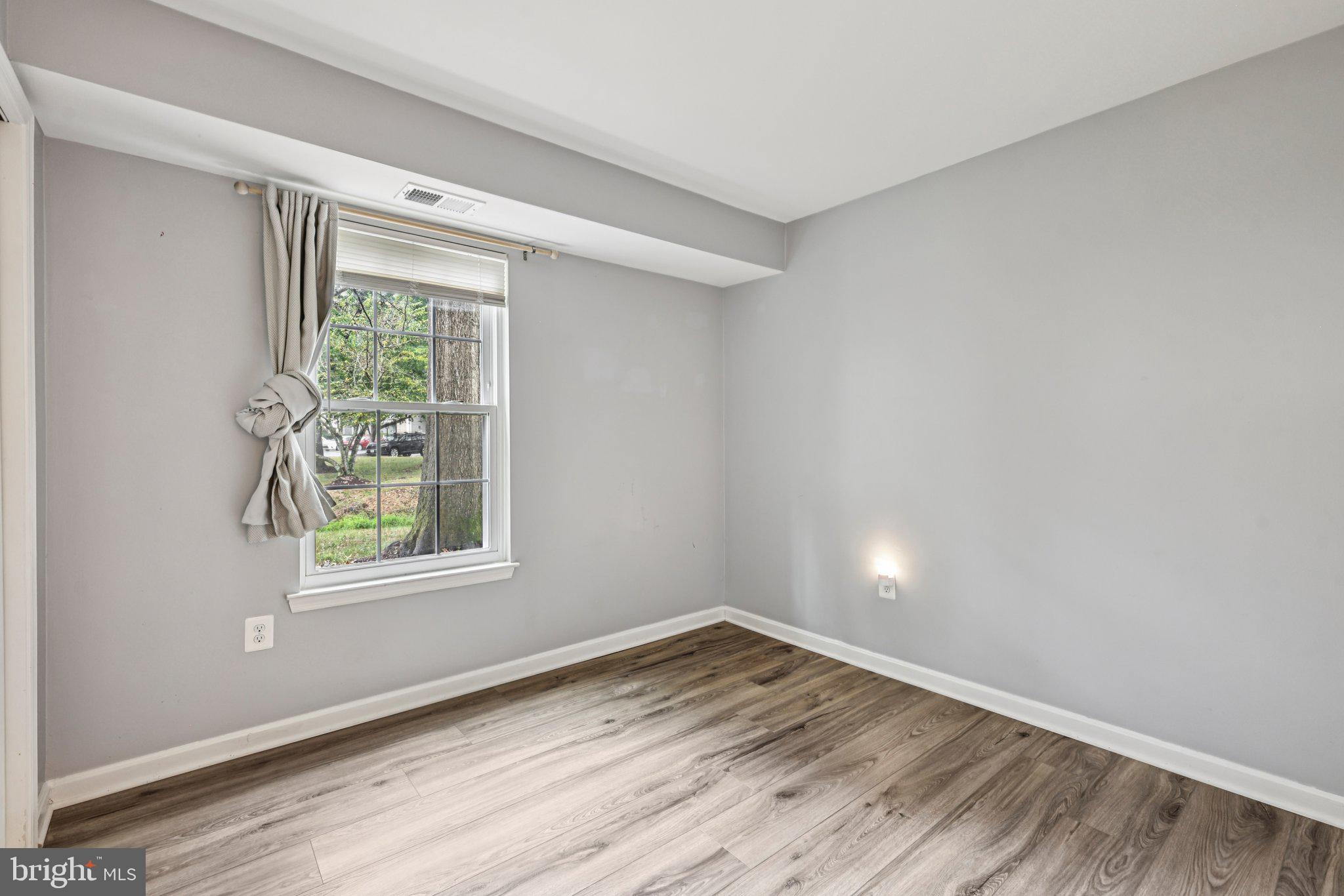 5707 Olde Mill Court, Unit 111 Alexandria, VA 22309 - Photo 14 of 32 an empty room with wooden floor and windows