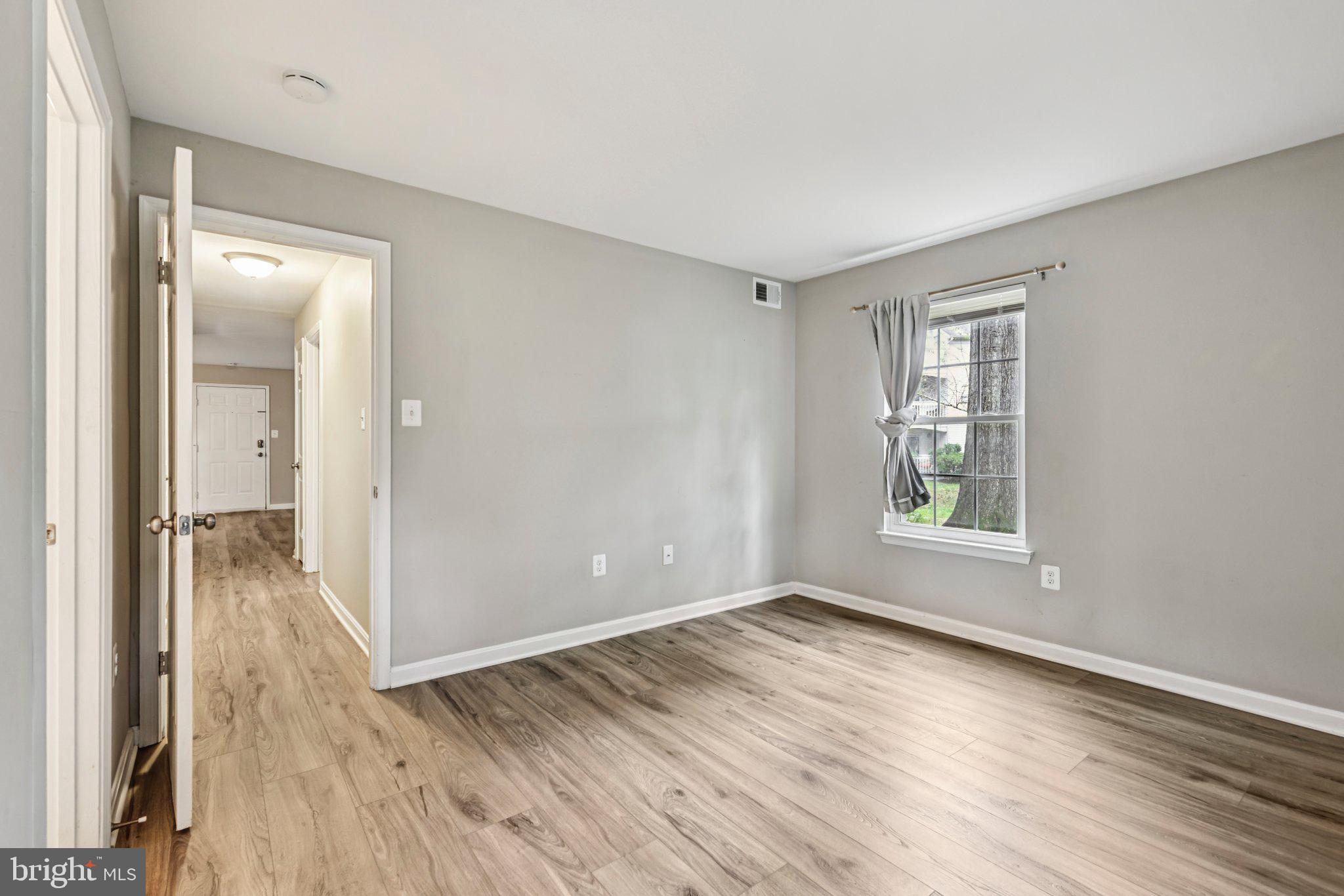 5707 Olde Mill Court, Unit 111 Alexandria, VA 22309 - Photo 21 of 32 an empty room with wooden floor and windows