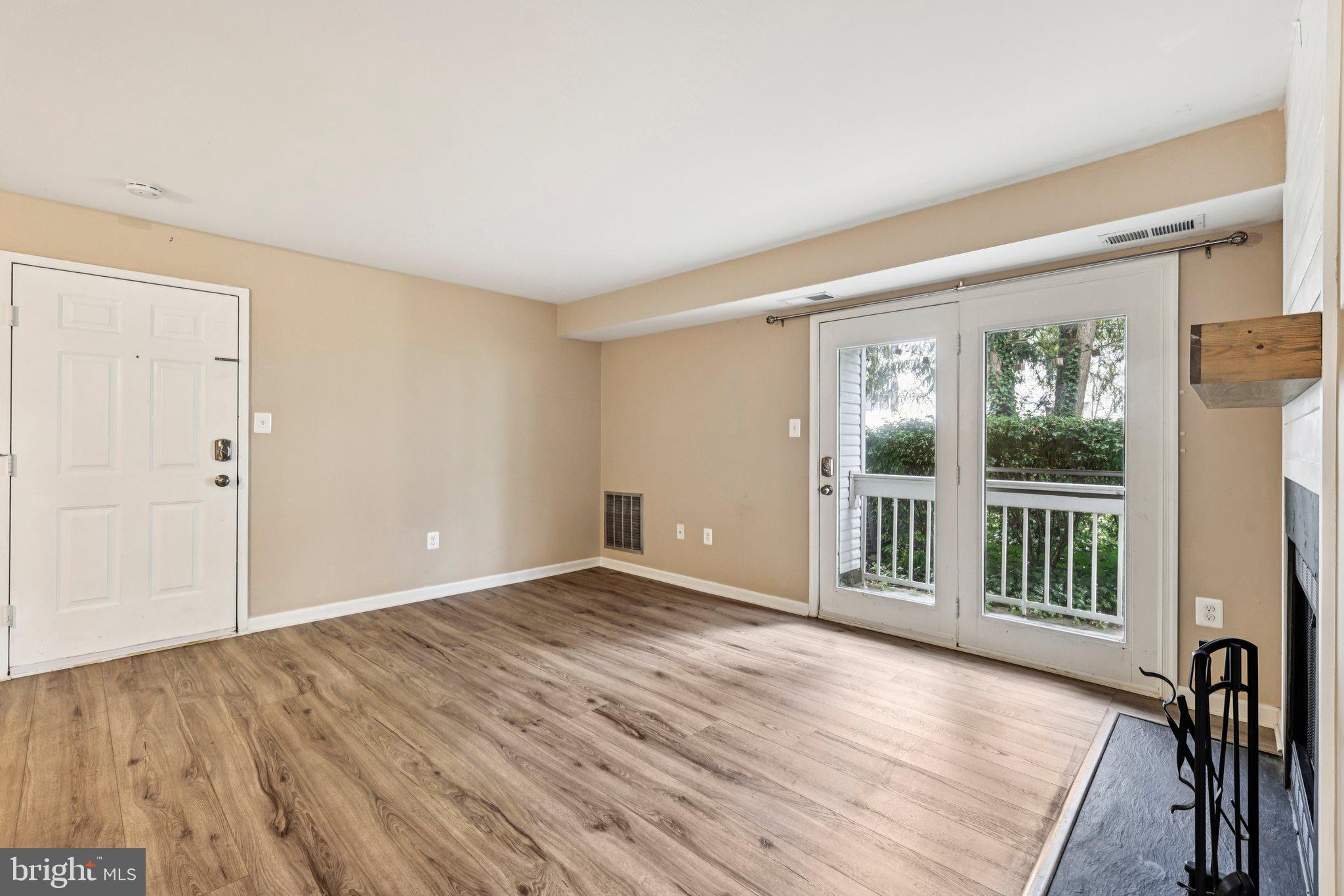 5707 Olde Mill Court, Unit 111 Alexandria, VA 22309 - Photo 3 of 32 a view of an empty room with wooden floor and a window