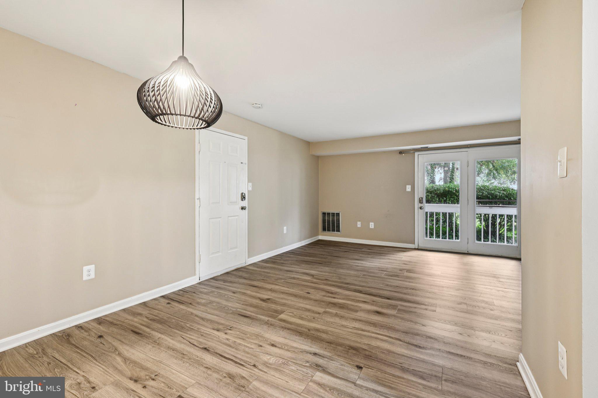 5707 Olde Mill Court, Unit 111 Alexandria, VA 22309 - Photo 4 of 32 a view of an empty room with wooden floor and a window