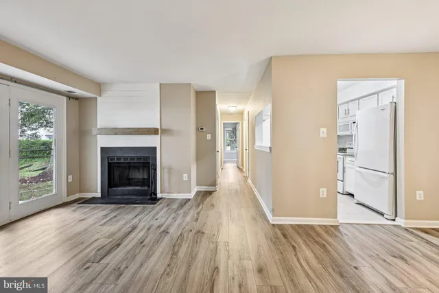 a view of a livingroom with wooden floor and a fireplace