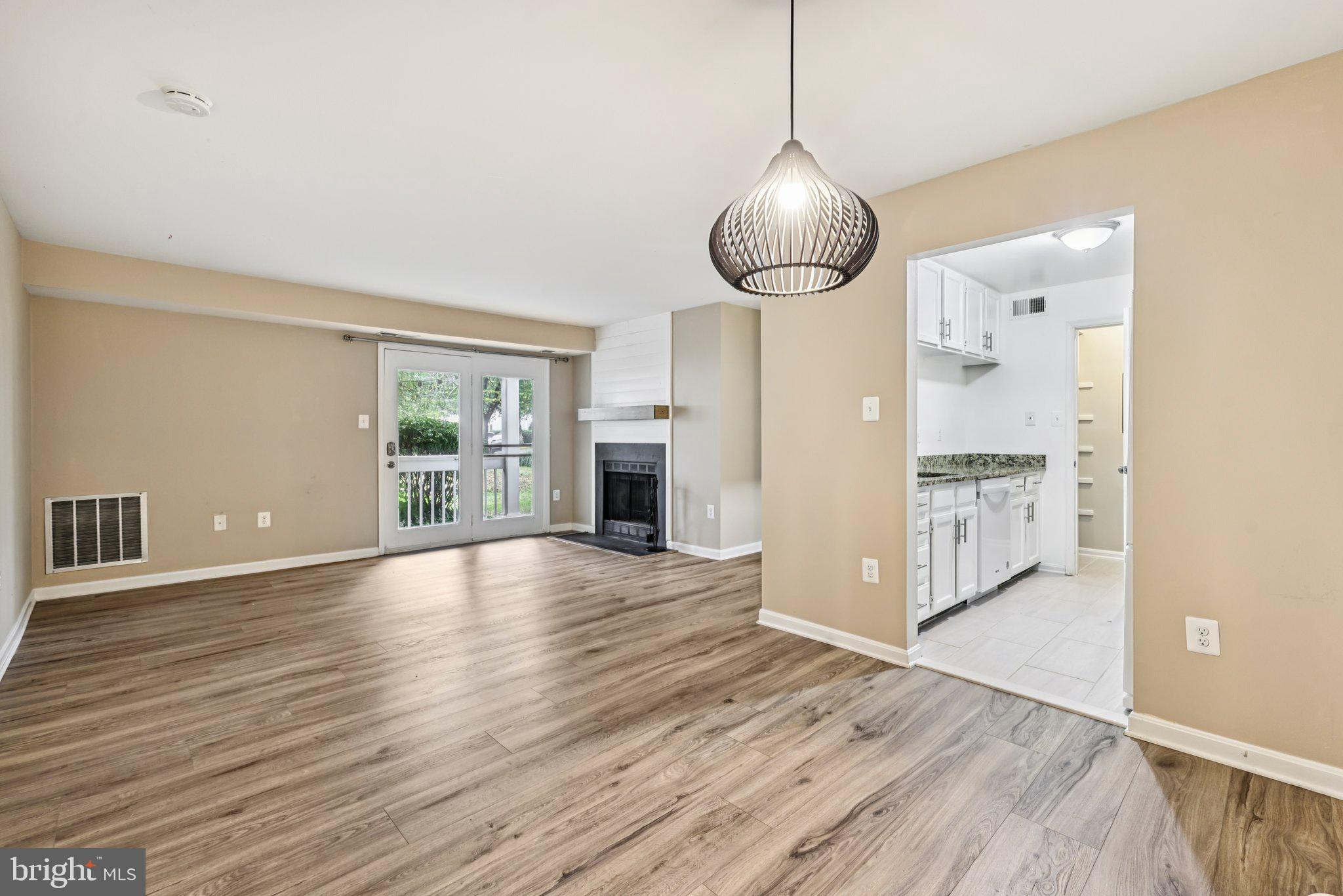 5707 Olde Mill Court, Unit 111 Alexandria, VA 22309 - Photo 9 of 32 a view of an empty room with wooden floor and a window