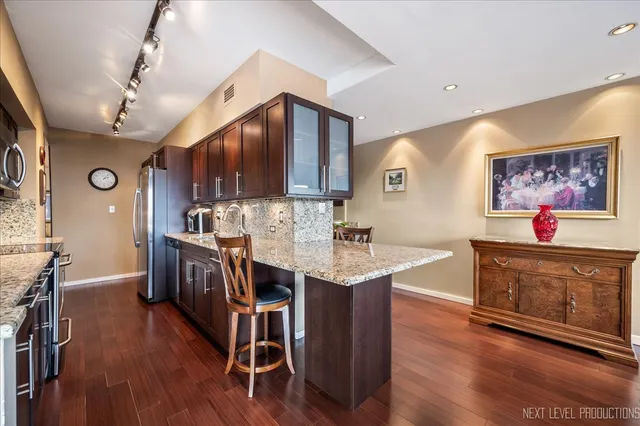 a kitchen with stainless steel appliances kitchen island granite countertop a stove a sink a microwave and a refrigerator