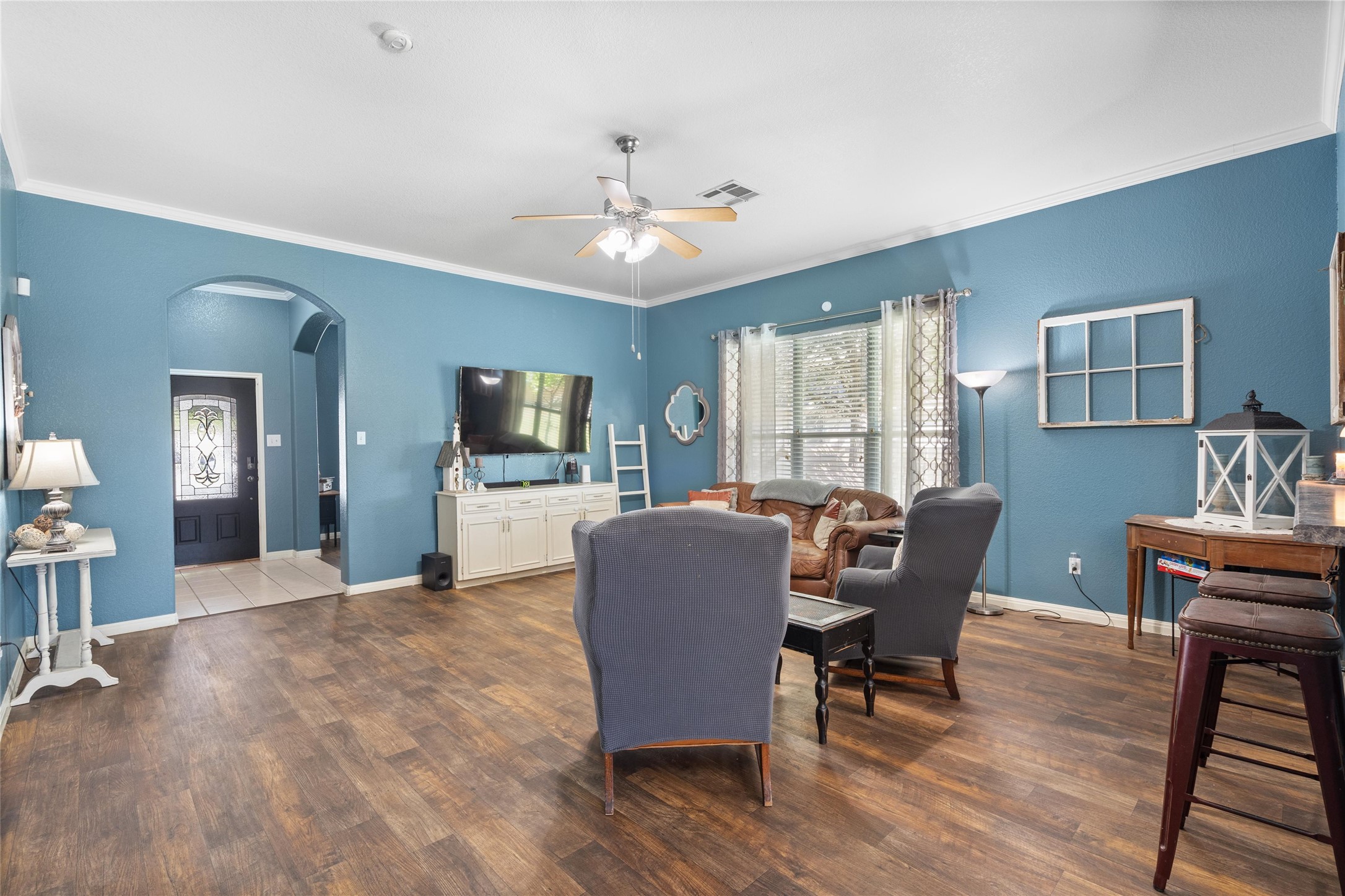 149 Dropper Kyle, TX 78640 - Photo 11 of 33 Rich wood-look floors, crown molding, and an arched entryway define this welcoming living space.