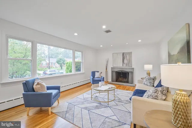 a living room with furniture a fireplace and a large window