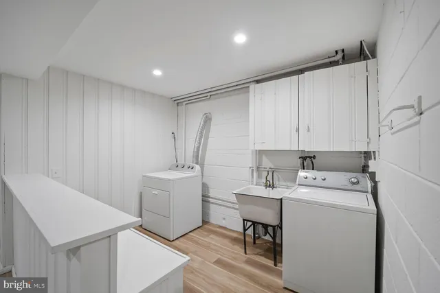 a utility room with cabinets washer and dryer