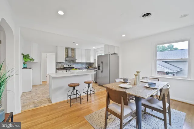 a kitchen with a dining table chairs refrigerator and cabinets