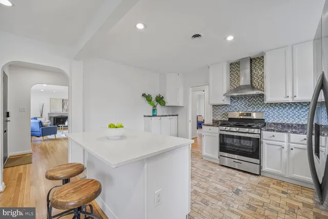 a kitchen with a stove a white table and chairs