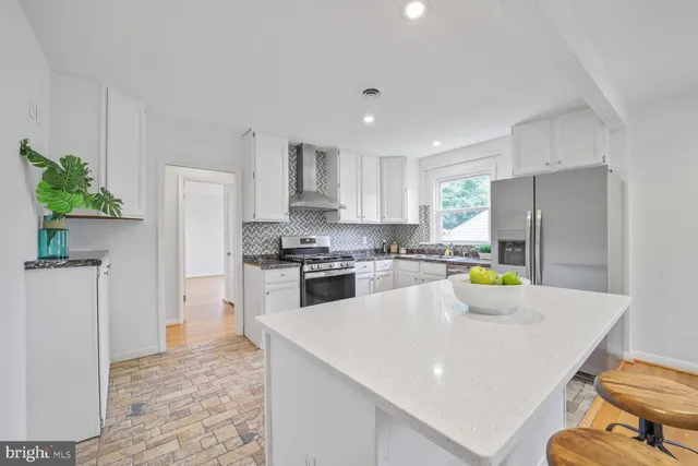 a kitchen with a sink a refrigerator and a stove top oven