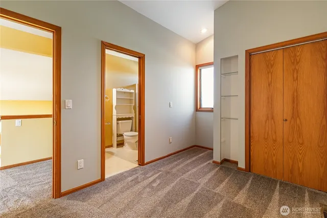 an empty room with closet and a window