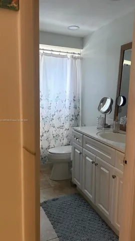 a bathroom with a granite countertop sink a toilet and shower