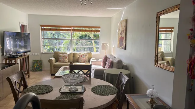 a dining room with furniture a large window and a fireplace