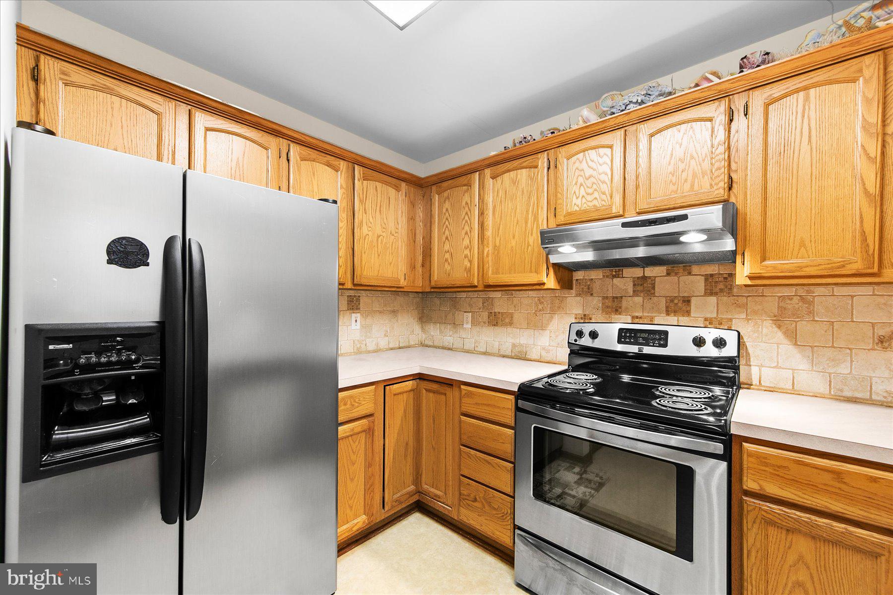 50 King Richard Road Ocean Pines, MD 21811 - Photo 11 of 28 a kitchen with granite countertop a refrigerator stove and cabinets